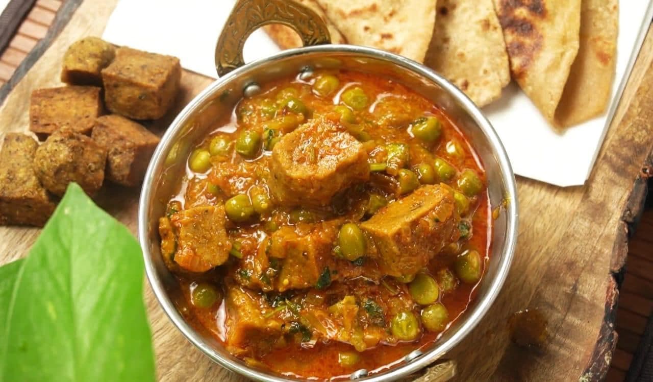 Sepu Badi curry simmered in a steel kadai, served with roti